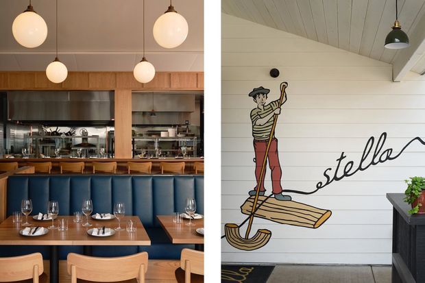 Split image of a stylish restaurant interior and its entry or exterior-facing wall. The restaurant side features blue upholstered banquette seating, timber dining tables and chairs, globe pendant lights, and an open kitchen framed by warm timber joinery and dark metal. The adjacent wall is clad in white horizontal boards and features a large nautical-style illustration with the word “stella,” plus a dark wall-mounted light and planter.