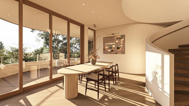 A warm, sunlit contemporary dining area with a long light-wood dining table and dark-framed chairs beside full-height timber-framed glazing. The glazing opens to a balcony or terrace with views of trees. A curved sculptural staircase and smooth curved ceiling forms define the space, with minimalist recessed lighting and an abstract artwork on the wall.