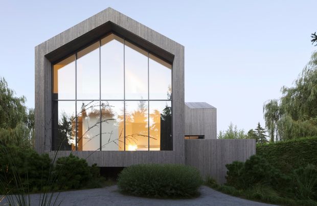 Exterior view of a contemporary residential building with a tall, steeply peaked glazed facade set within dark vertical timber cladding. Floor-to-ceiling windows reflect surrounding vegetation and reveal a warm-lit interior, while a lower timber-clad wing and landscaped garden frame the entrance approach.