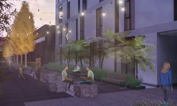 Architectural visualization of a contemporary multi-storey building with a pale rendered facade, tall narrow windows, exterior wall lighting, and a landscaped pedestrian courtyard. Fern plantings, benches, stone seating blocks, paving, and small groups of people create a communal outdoor space at dusk.