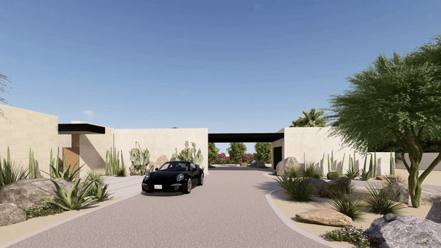 A wide architectural exterior view of a minimalist single-storey residence or development entrance in a dry, desert-like landscaped setting. Pale rendered or stone-coloured walls form low geometric volumes around a broad paved driveway, with a dark flat-roofed canopy or linking element spanning the central opening. Drought-tolerant planting includes agave, columnar cacti, yucca-like plants and sculptural trees, with large natural boulders integrated into the landscape. A black sports car is parked in the foreground, and additional landscaped buildings or courtyards are visible beyond the entrance.