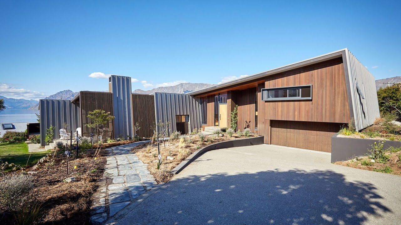 Overlooking the majestic mountains of Lake Hawea this architecturally designed home nestles in to the slope and offers privacy and seclusion. The angles of the exterior create reflects the mountains beyond. video