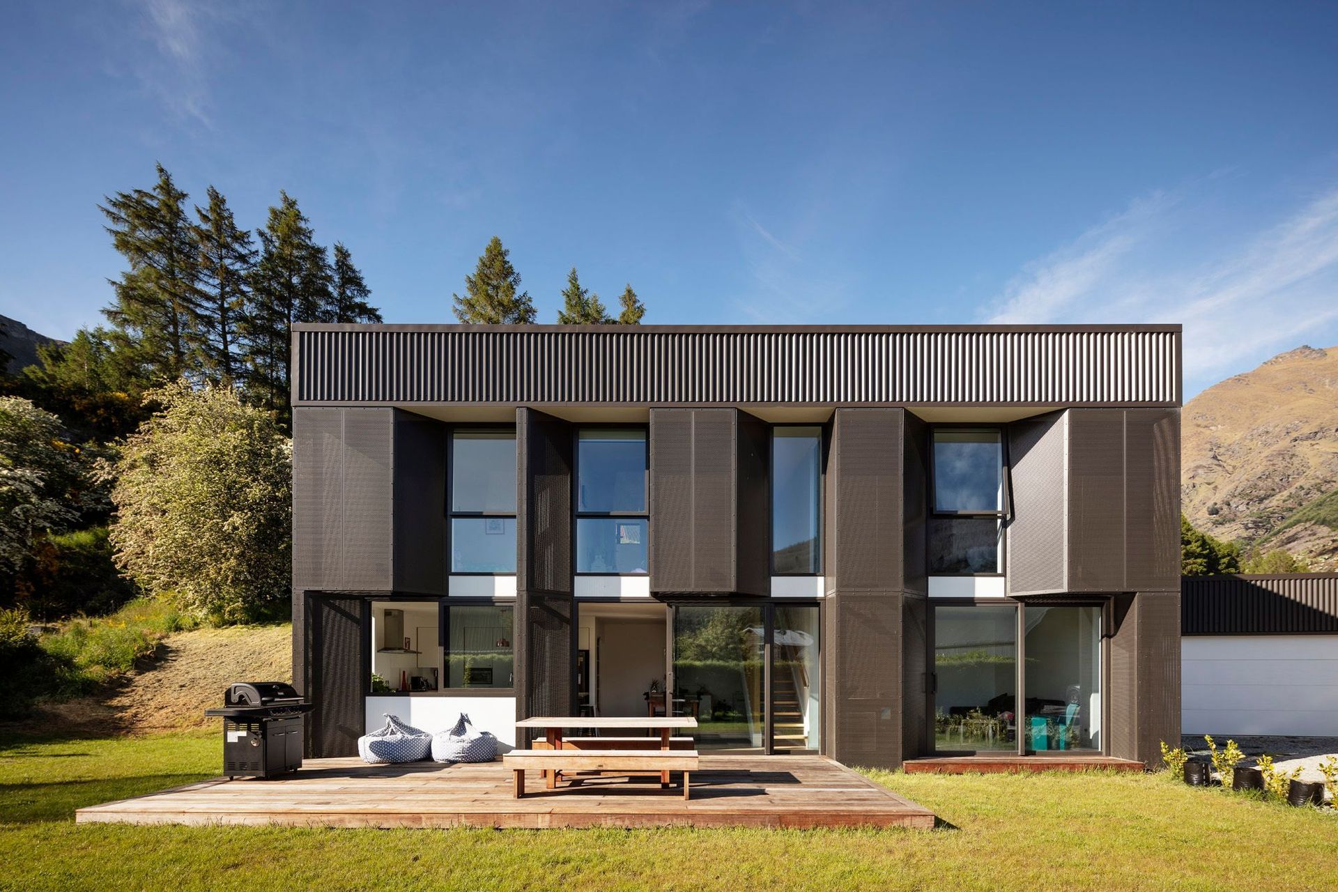 Built on a tight budget, mesh screens provide shading over low-E, double-glazed, thermally broken aluminium joinery on Arthurs Point Steel House by Team Green Architects. Photograph by Sam Hartnett.