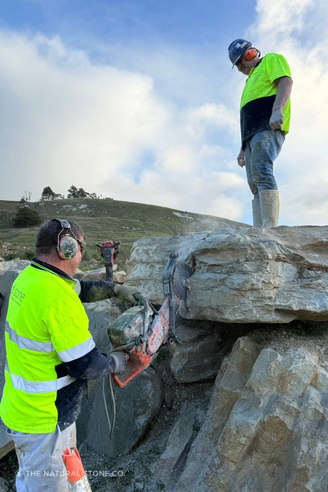 Cutting a Te Ākau limestone boulder at the quarry, where large-format stone pieces begin with careful extraction and an understanding of the material’s natural scale.