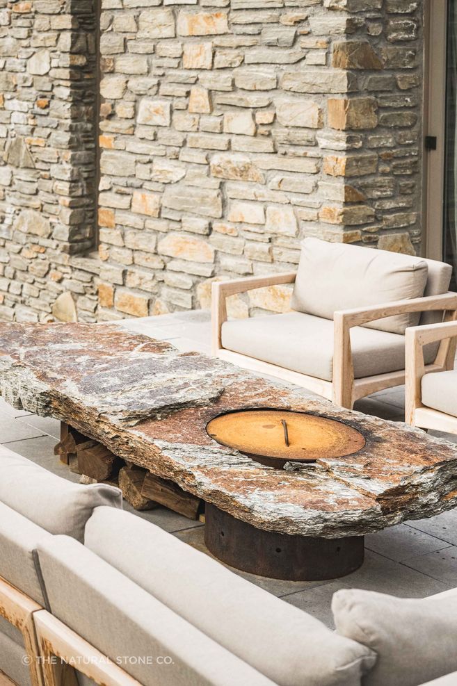 A schist  wall grounds the home and anchors the schist firepit, both by The Natural Stone Co.