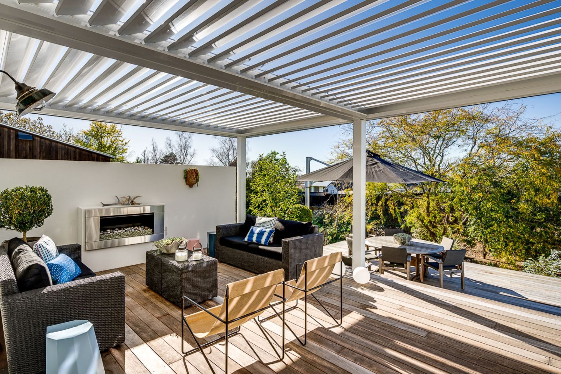 This cosy outdoor area with fireplace is enhanced with a louvre system that allows light in when it's sunny and provides protection from the rain when the louvres are closed.