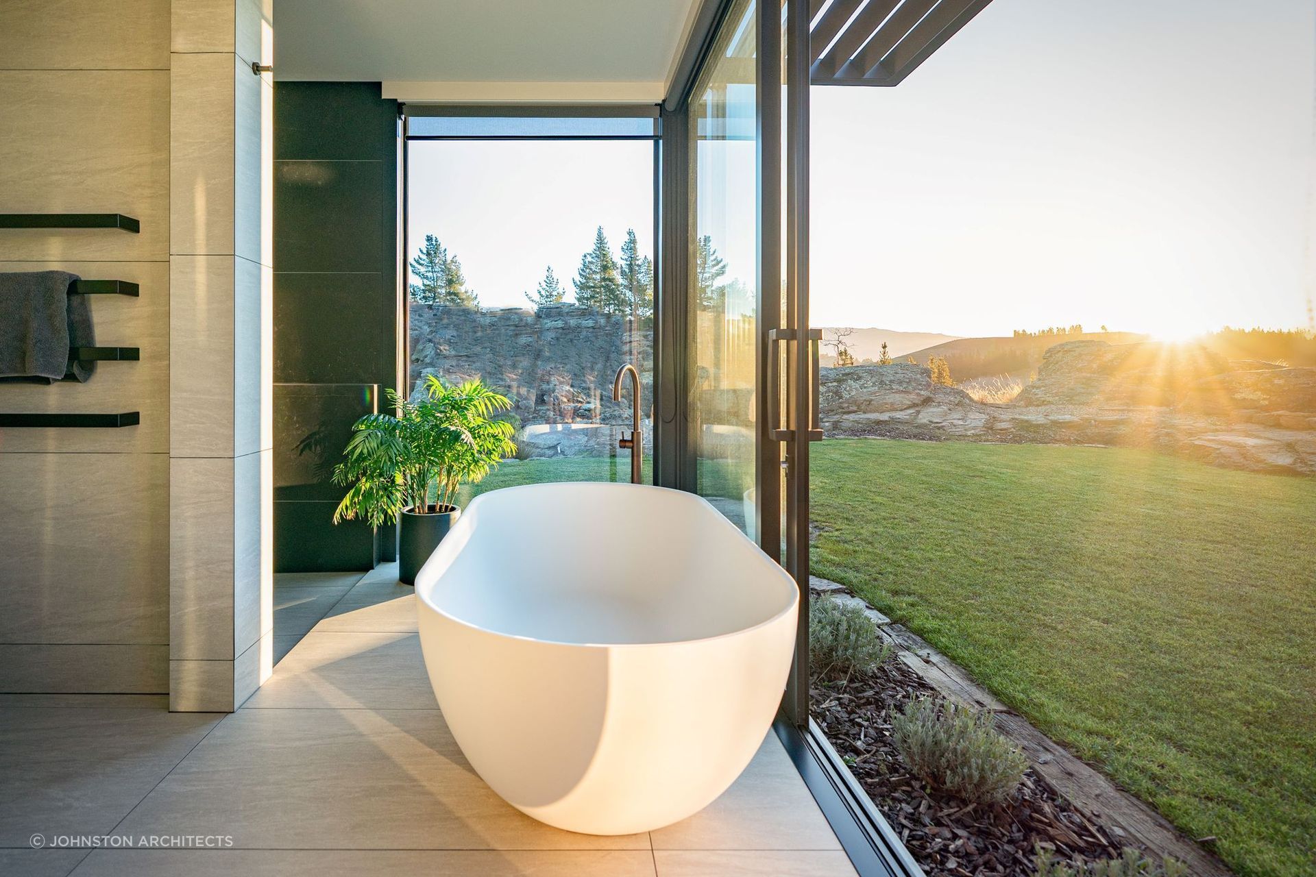 Sliding doors allow the crisp alpine air to breeze through the exquisite bathroom of the Earnscleugh Ridge Retreat — Photography: Larkin Photography