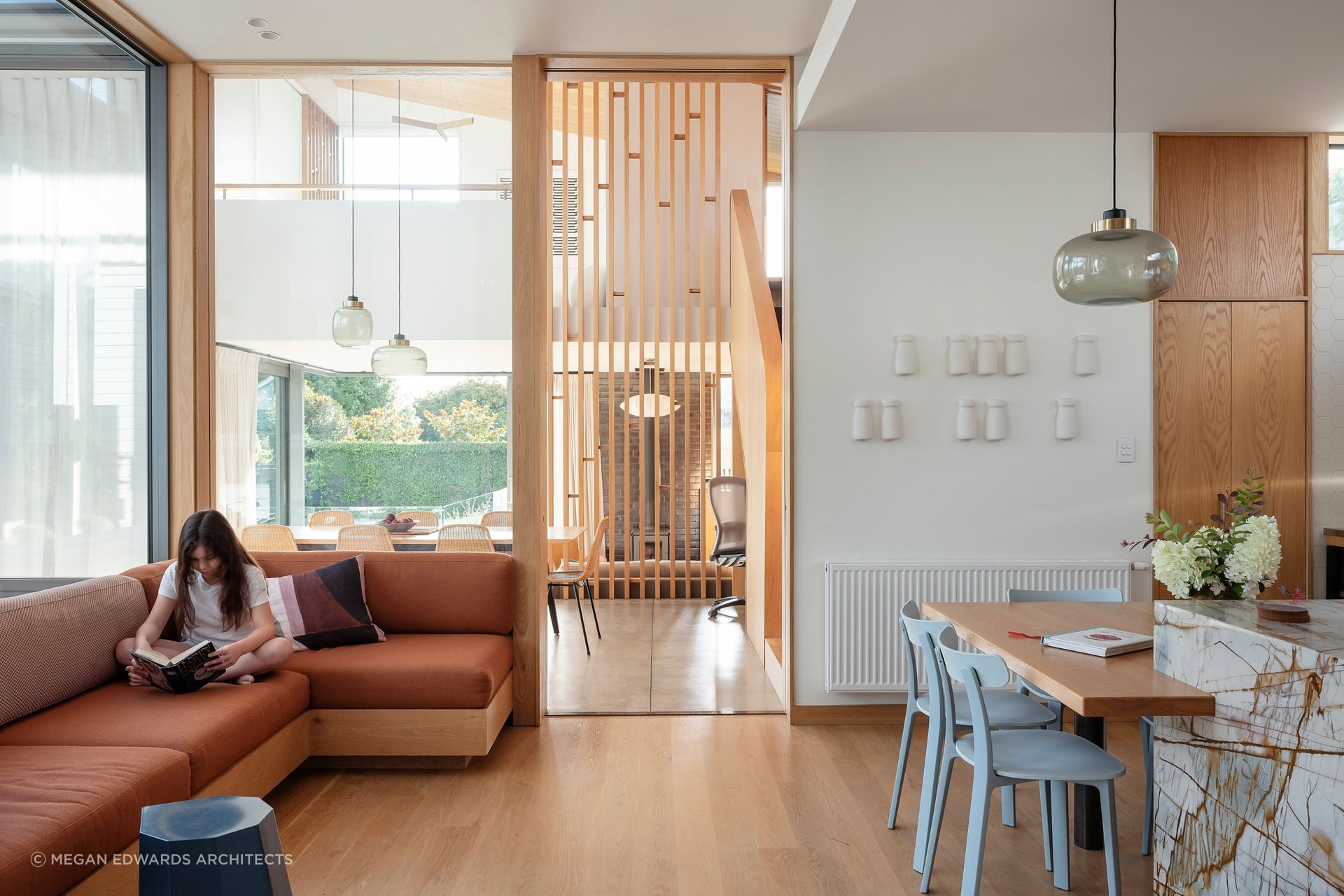 In this larger house, a timber screen separates living and dining, whilst a glazed panel and cavity slider provide acoustic separation from the kitchen/family room when required.