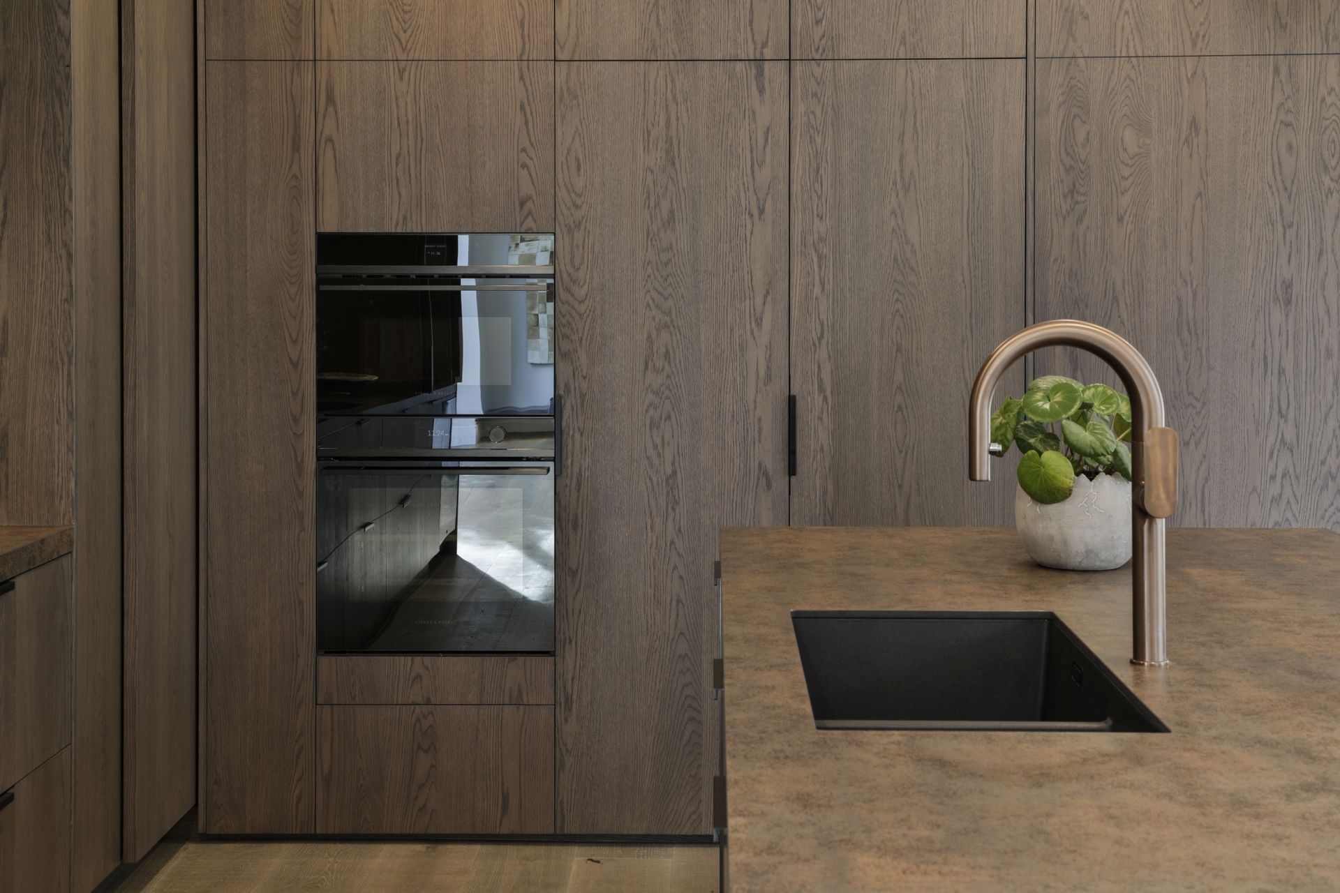 American white oak veneer was chosen for this kitchen project as its pronounced grain adds a rustic touch to the sleek space.