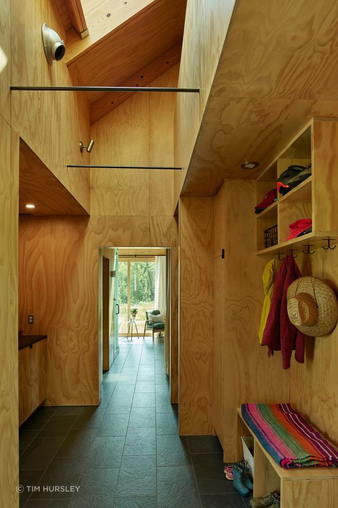 More plywood forms a bench and shelves in the mudroom, where a porcelain tile floor adds durability.