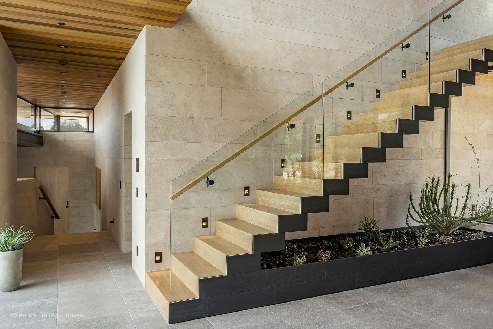 The project’s most demanding detail, structurally, is a cantilevered staircase wrapped entirely in wood with no visible support, engineered around tube steel embedded deep in the adjacent wall. It was fabricated not by a stair manufacturer but by the clients’ own aerospace manufacturing facility, whose team worked directly with Neubert’s to prototype and execute it, a level of custom fabrication he says he wishes he had on every project.