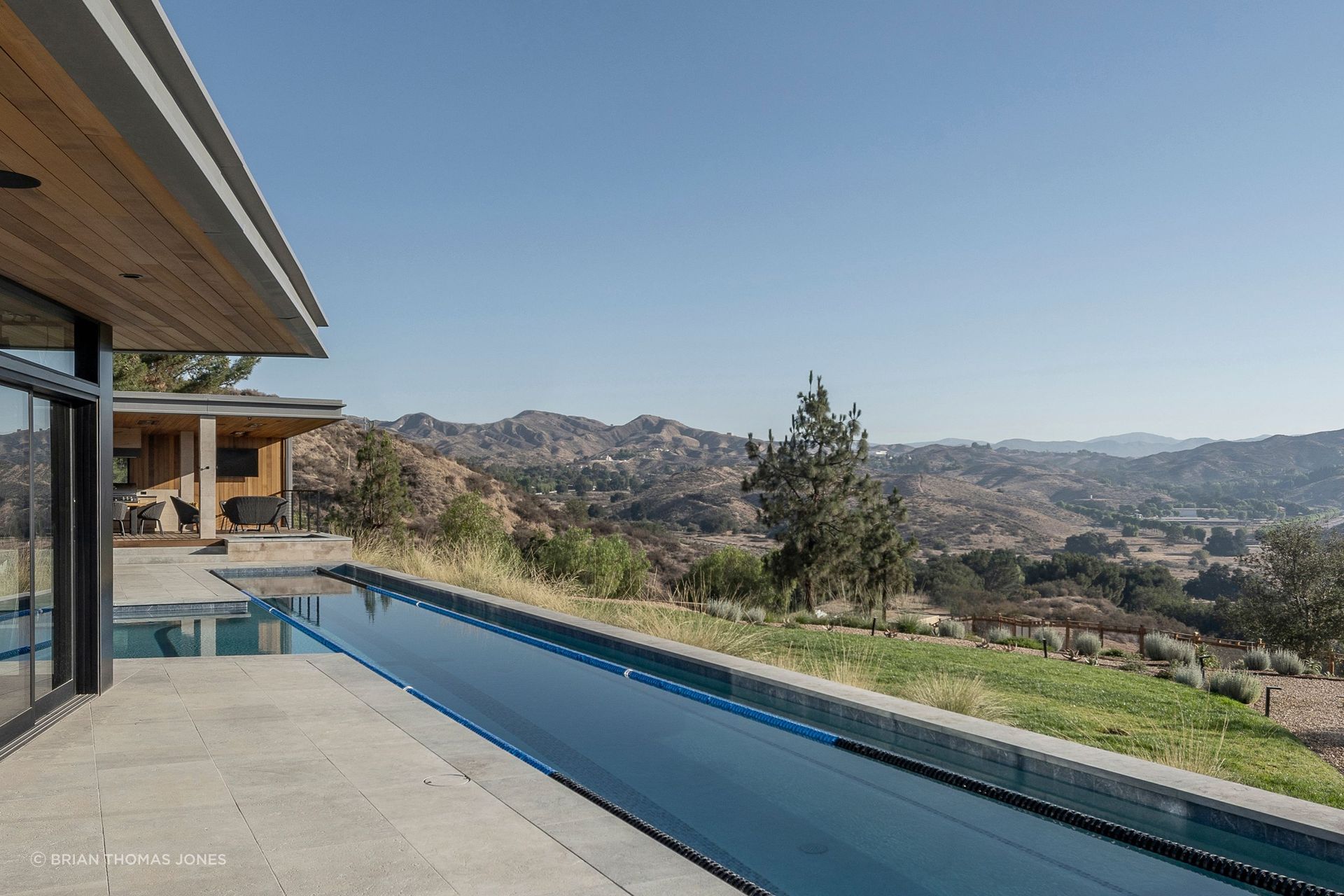 Ceiling-mounted infrared heaters and passive ventilation keep the terrace livable most of the year, and a T-shaped pool combines a lap lane, where the husband, a former high school swimmer, does laps most mornings regardless of the uncovered pool’s temperature.