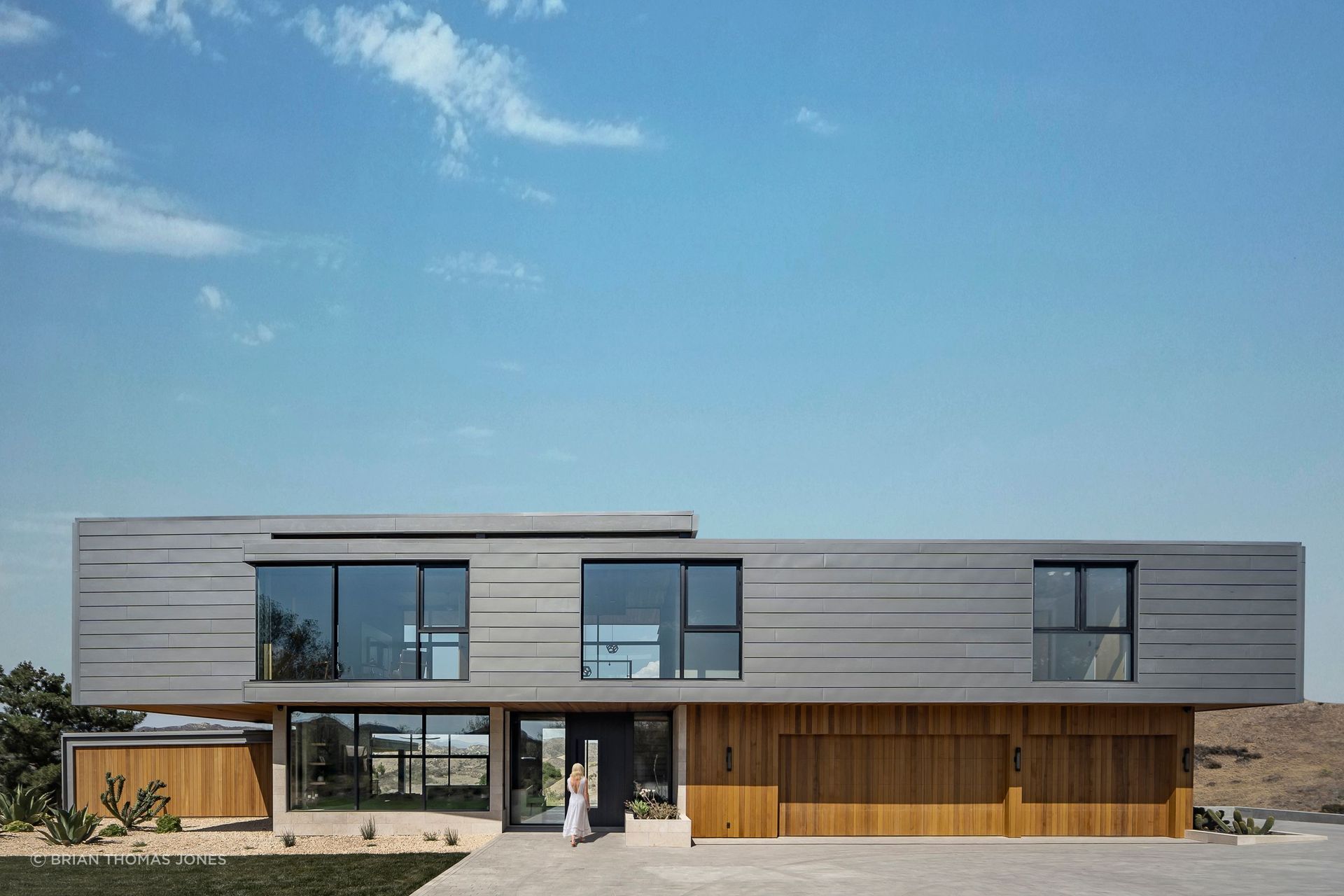 The entry side is largely opaque, broken only by punched windows.