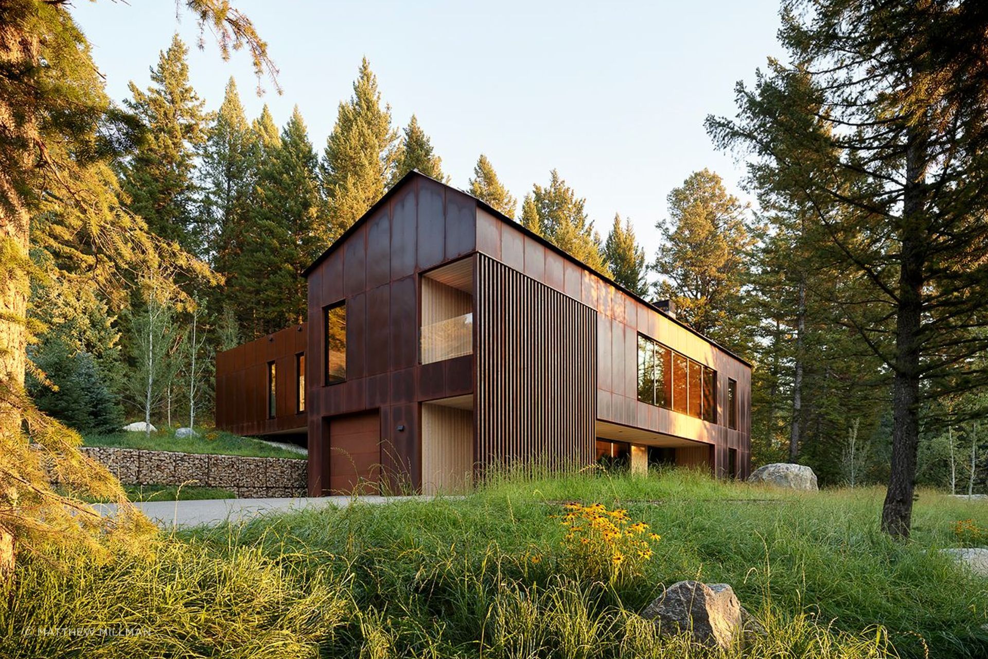 The living finish of the weathered Corten steel exterior provides a dynamic backdrop for the natural surroundings, while carved-out sections of larch provide a warm contrast and highlight the home’s sculptural form.