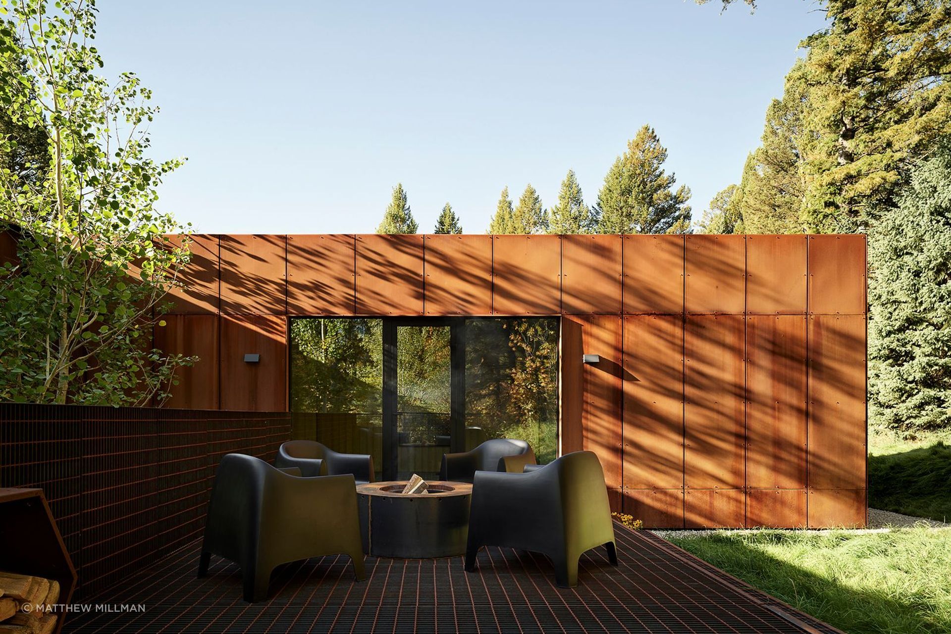 Outdoor spaces, including a rear metal grate deck that encircles a pair of aspen trees and a front deck extending from the kitchen offering prospecting valley views, further enhance the home’s integration with its environment.
