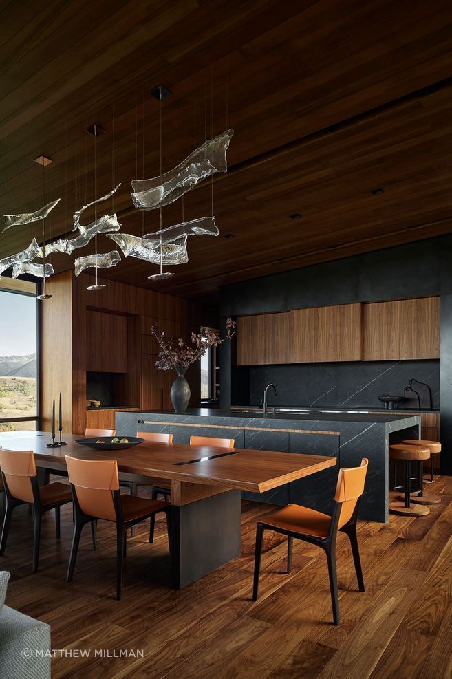 The interior palette of Skyview incorporates earthy tones—sage greens, ochres, and burnt oranges—to ground the design within its mountain setting. Custom details, including a curvilinear light sculpture and a hand-crafted dining table, reveal a commitment to craftsmanship on pieces that will stand the test of time.