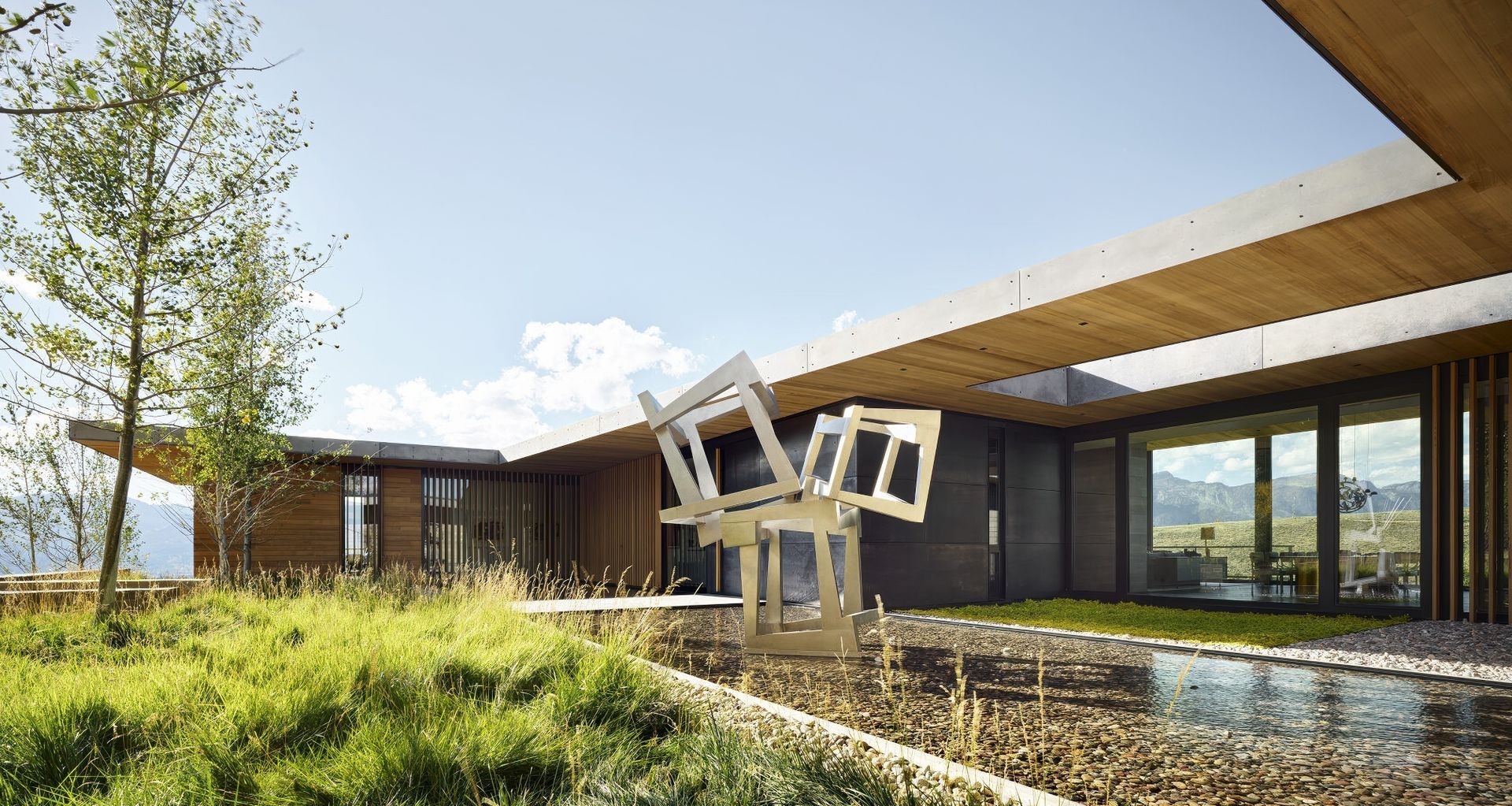 Envisioned as a multi-generational retreat, this CLB Architects' project located in Jackson, Wyoming, serves as both a family sanctuary and a living gallery. Central to the design is a stainless steel sculpture by Jedd Novatt, commissioned by the owners and a longtime anchor of their personal collection, a poignant reminder of shared familial bonds over a deep appreciation of art. Photo by Matthew Millman