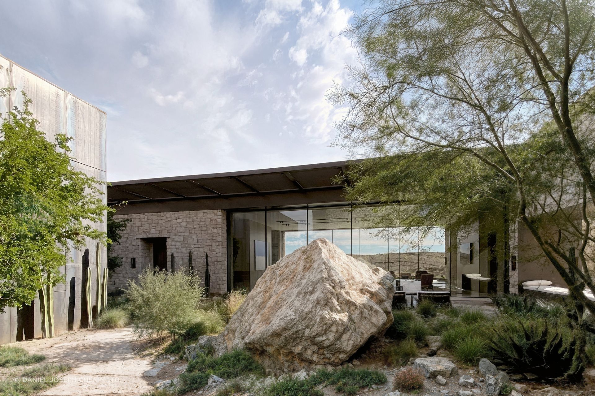 The arrival courtyard establishes a quiet dialogue between architecture, native planting, and the existing desert landscape, creating a gradual transition from exterior to interior.