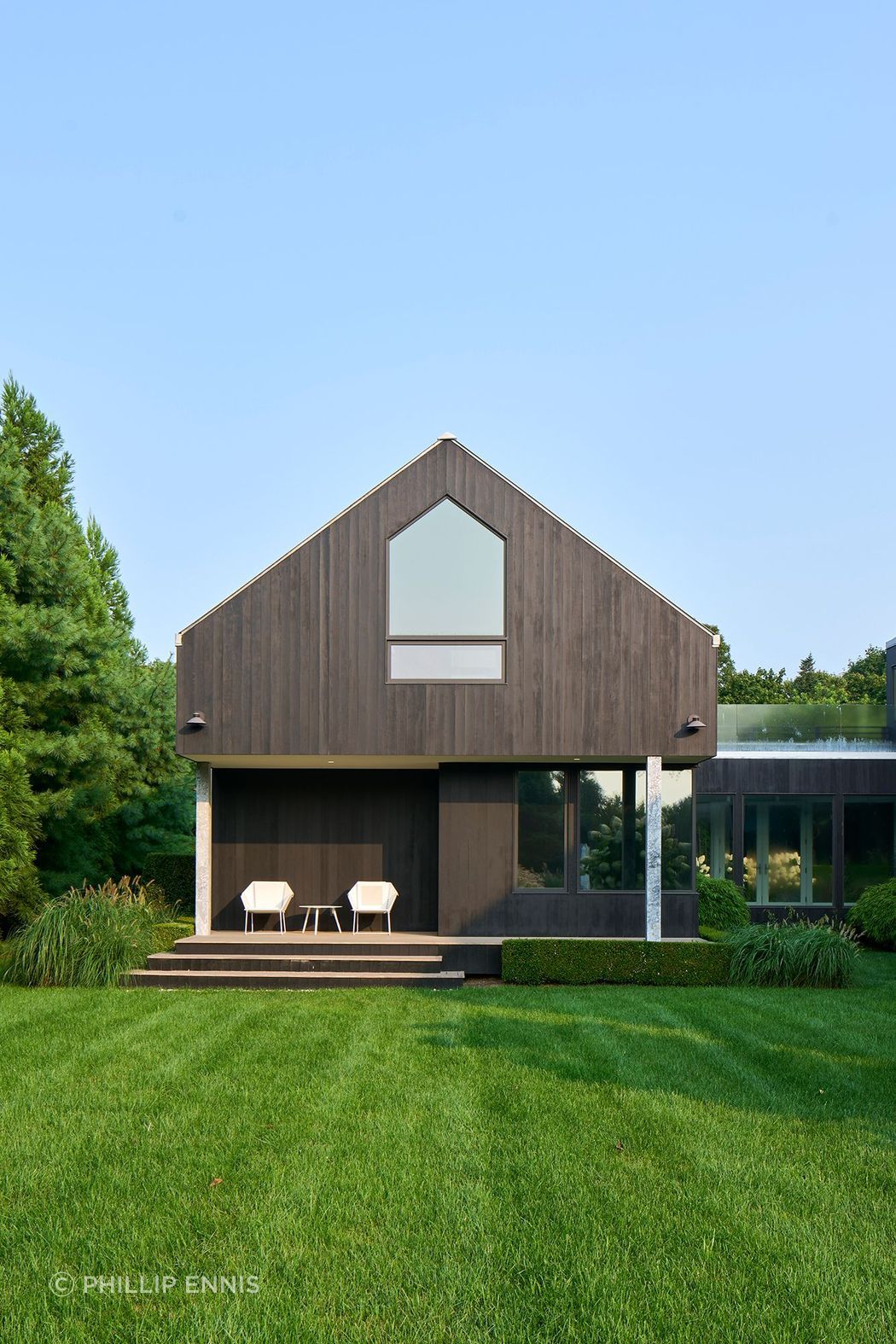Materially, this Hamptons house is expressed through a restrained palette. Exterior walls are clad in ebonized cedar, complemented by a standing seam Galvalume roof and anodized aluminum windows.