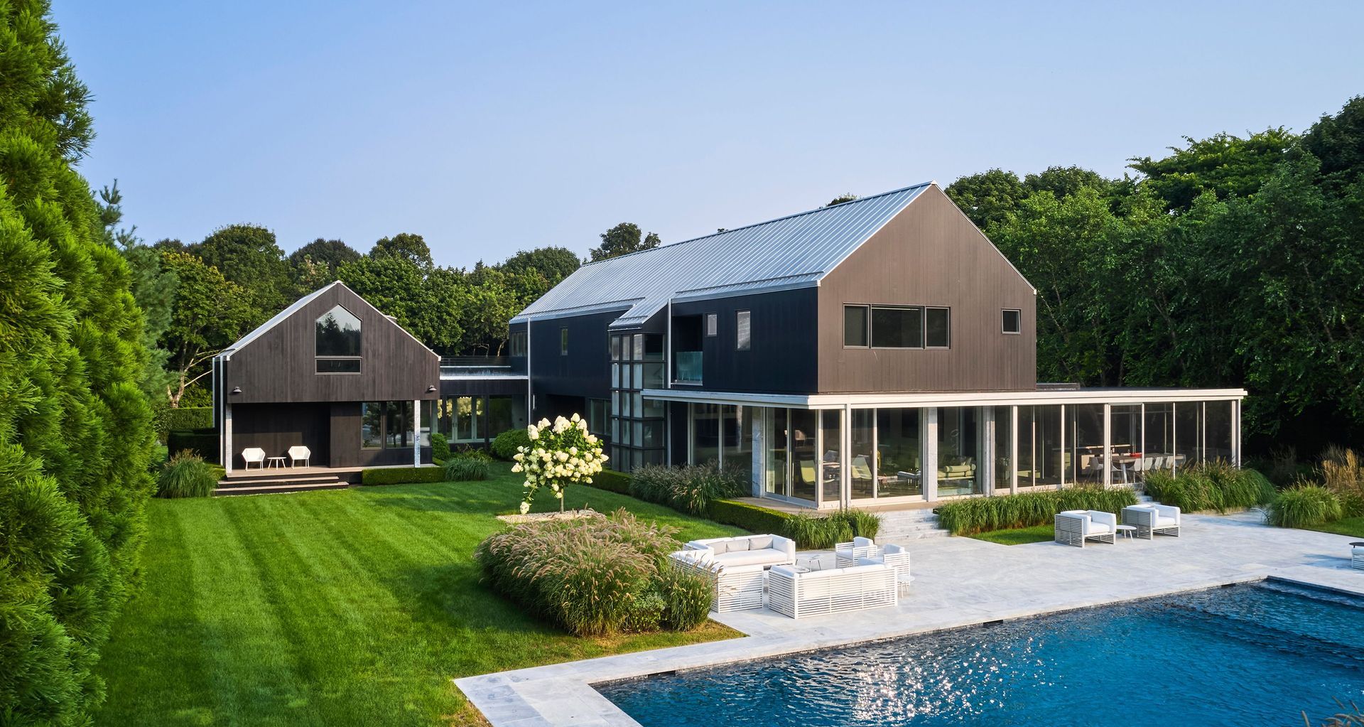 Conceived as a vacation residence for a Manhattan couple and their extended circle of family and friends, this Hamptons project occupies a flat, one-acre parcel within a wooded subdivision. The rear of the site abuts a large agricultural facility, whose scale and rhythm subtly informed the architectural response. Photo by Phillip Ennis