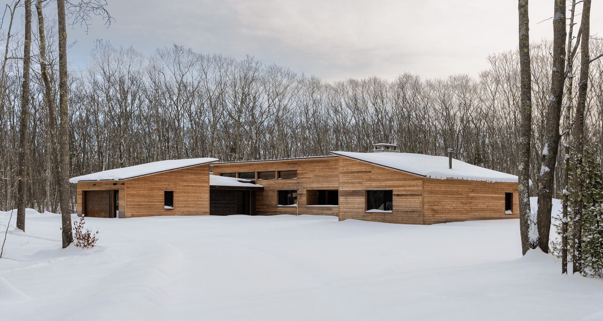 Branch House by OPAL Architecture asks and answers the design question: what if we transport the concept of the ranch house, a single story, low profile structure with an open interior engaged with exterior spaces, to a forested Maine setting and climate. Photo by Erinn Simmons and Gabe Tomasulo.