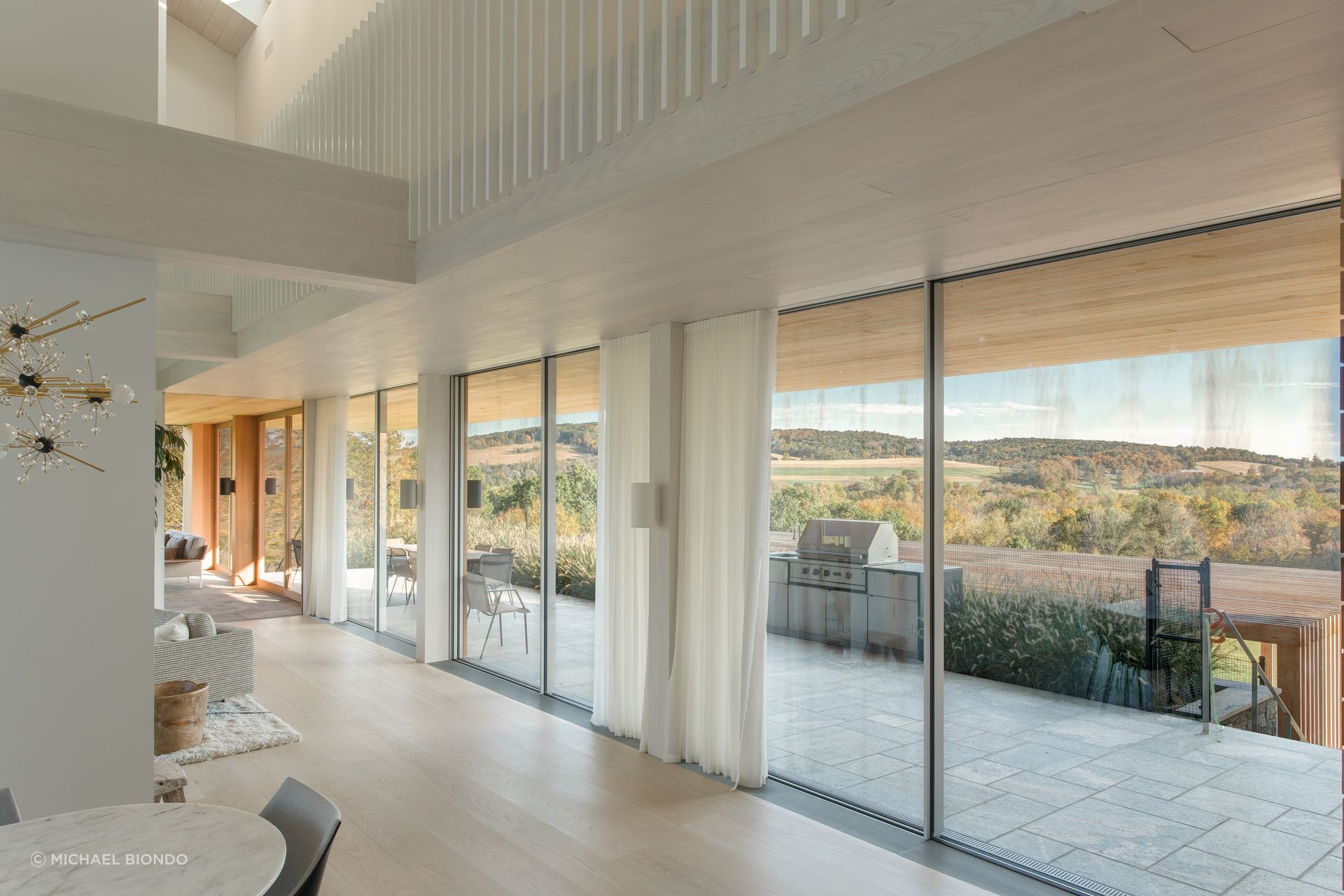 A covered outdoor terrace overlooks the pool, and provides a panoramic view unobstructed by columns.