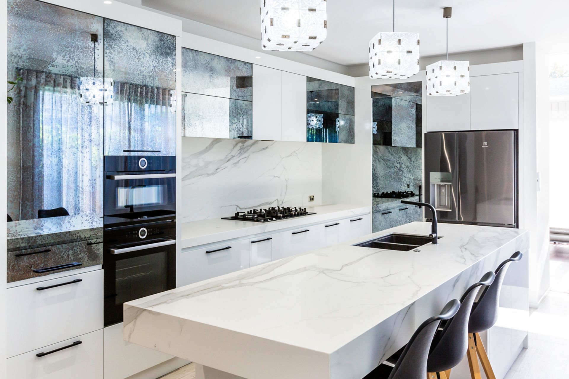 This kitchen demonstrates how versatile antique mirror is, working in easily  with a contemporary aesthetic.