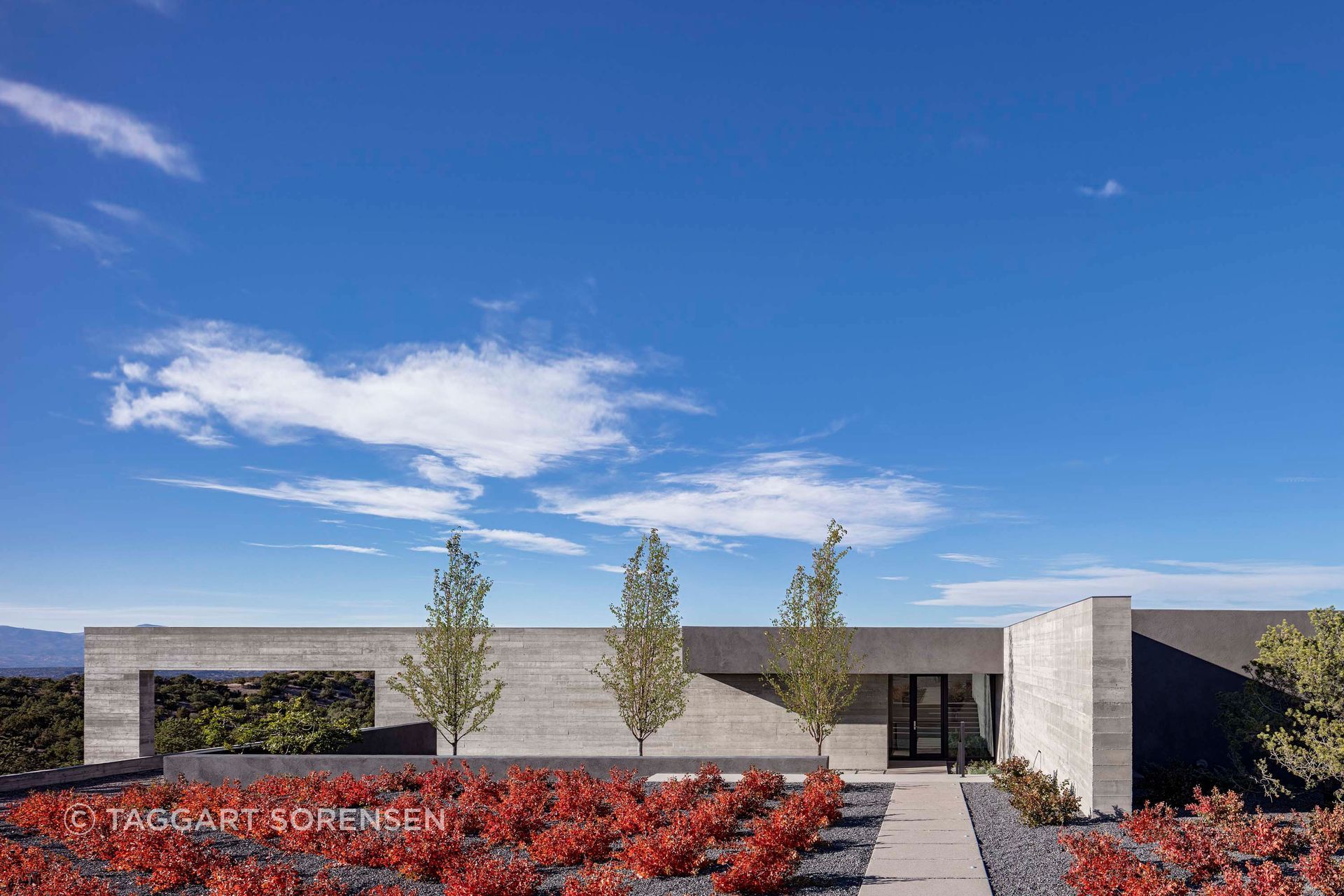 Sangre de Cristo House by Specht Novak sits low against the New Mexico landscape, using concrete, courtyard planting and a restrained horizontal form to respond to climate, terrain and vast mountain views.