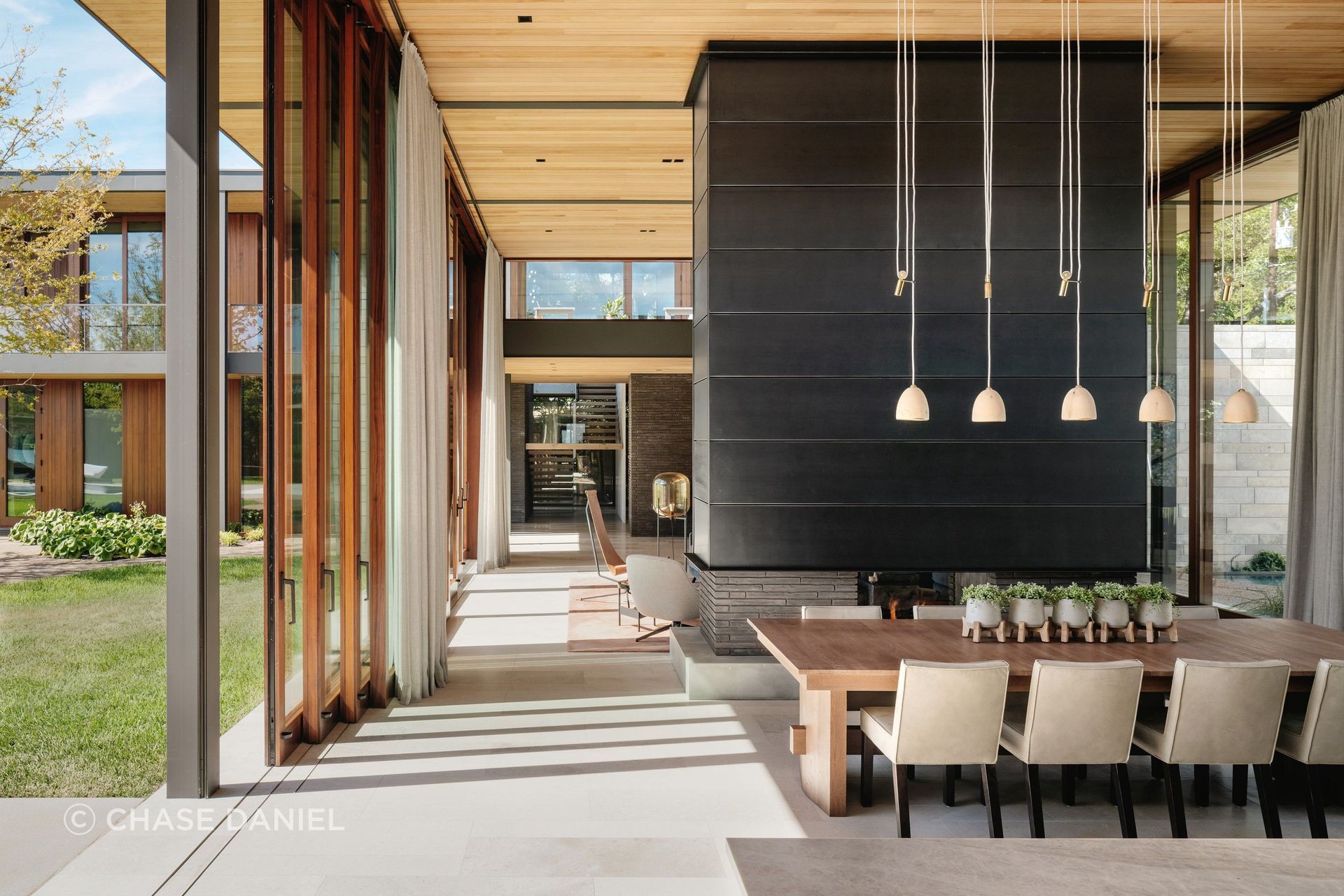Water's Edge is composed of large glass walls on both sides of the central living volume that can open completely, and motorized solar screens drop down to turn the entire center of the house into a screened porch when the weather allows, keeping bugs out without closing the space in.