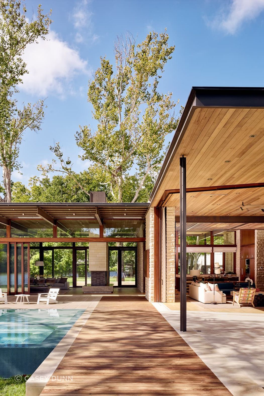 At the glassy center of the Lake Austin home, the structural system is exposed to reveal a rhythmic steel vertebrate that organizes the primary public spaces and provides definition and scale to the spacious rooms.