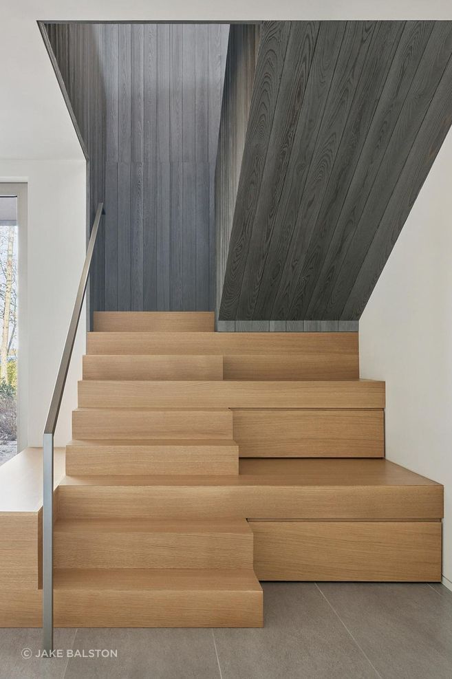 “The staircase near the entrance also serves as a tiered seating bench,” Chia says. Touch-latch panels on the face of the risers conceal hidden storage compartments.