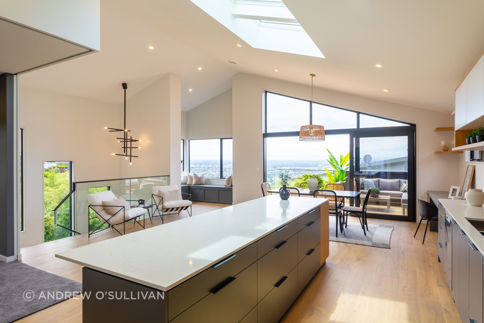 The stunning benchtop with waterfall end in this kitchen are engineered stone from Handcraft Kitchens and Joinery - colour is Cielo.  The kitchen units are a mixture of Prime Melamine Anthracite, Melteca Snowdrift and Melteca Sublime Teak, with cabinetry pull handles.