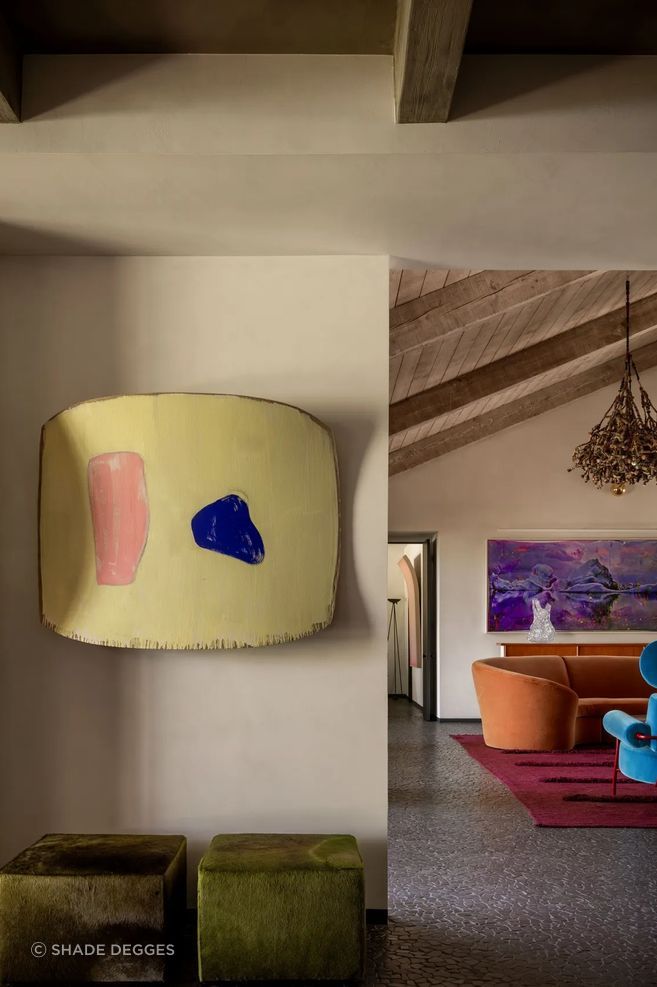 In a corner of the family room, a Ron Gorchov painting is displayed above a pair of vintage cowhide ottomans. Art: Ron Gorchov