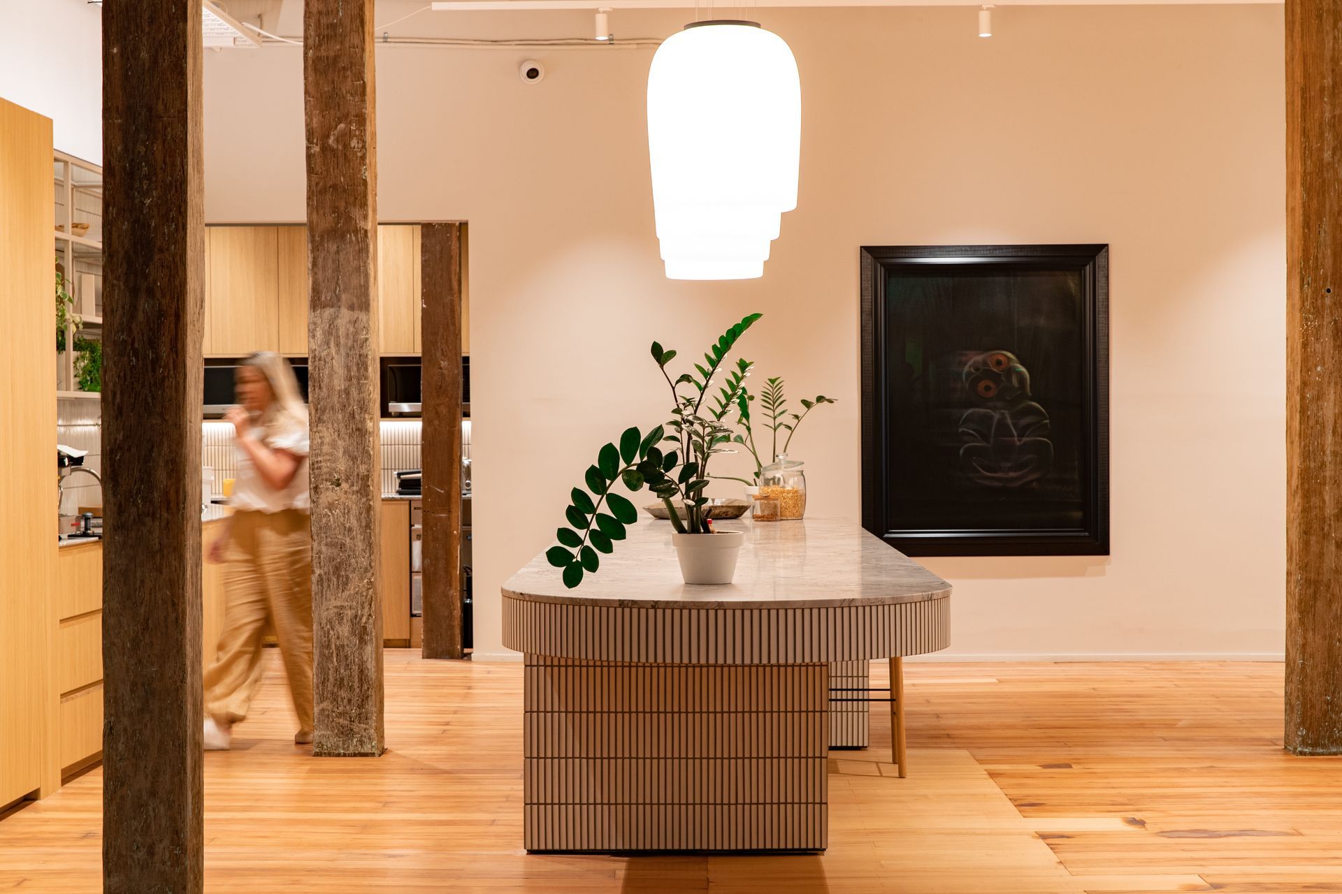 The kitchen, designed around the jarrah beams and with generous space for team collaboration at the kitchen island. | Photographers: Oliver Compton &amp; Millie Cossou