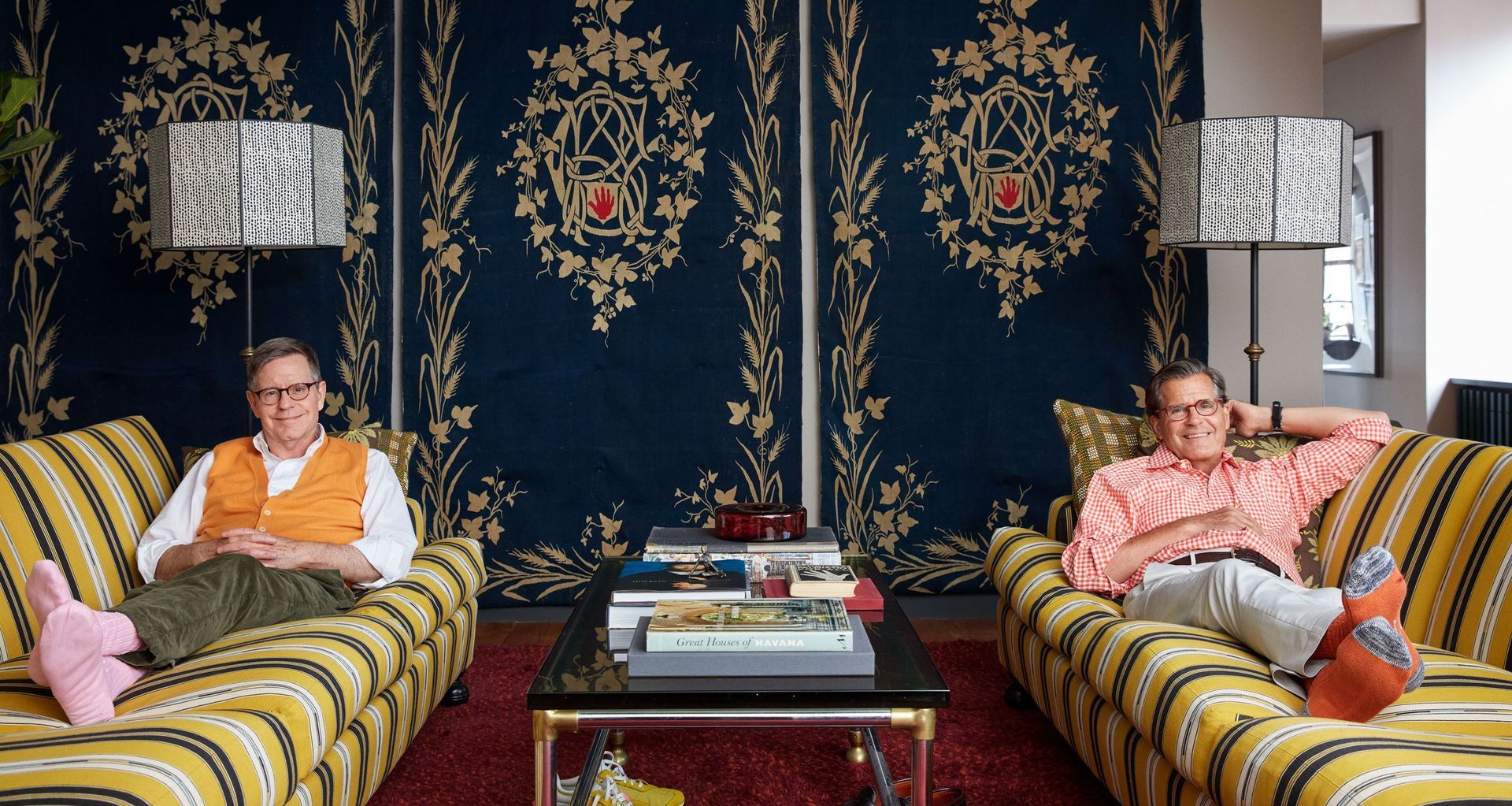 LaForce (left) and Henderson recline on the twin sofas, each upholstered in a Pierre Frey stripe; the mounted fabric panels are Roman shades bought from an auction of the John Richardson estate.