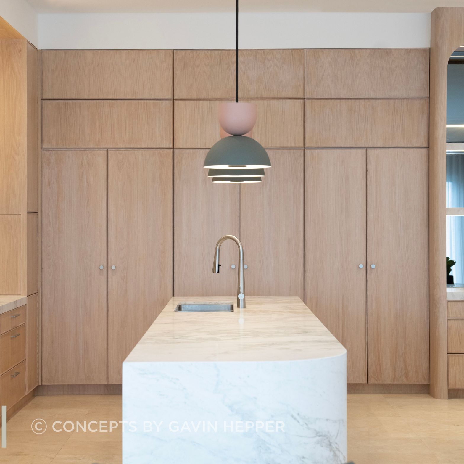 Coastal luxury.  Limewash oak cabinetary compliments the beautiful natural stone island.