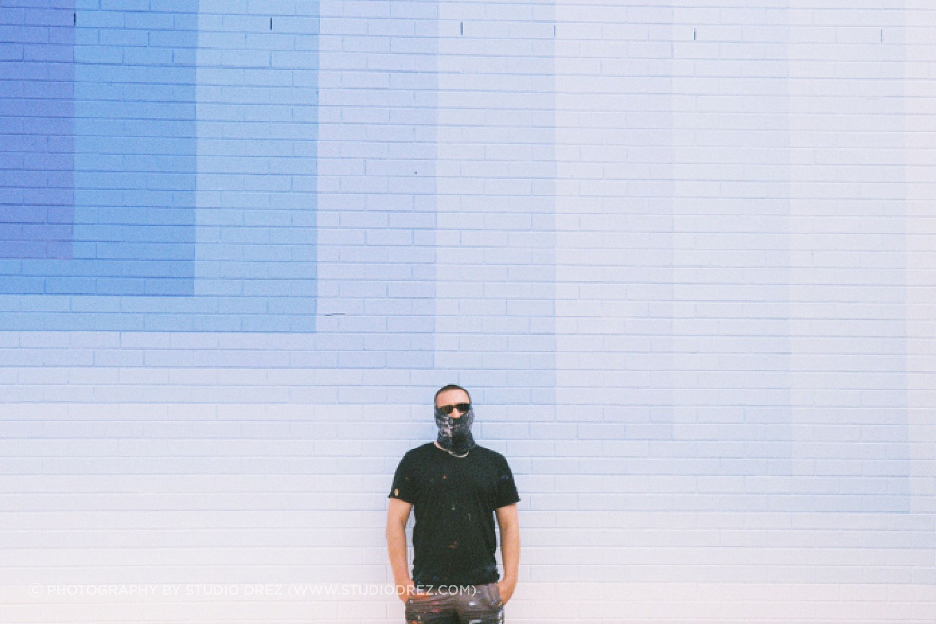 Melbourne street artist Drez stands in front of a mural he created for the Benalla Street Art Festival.