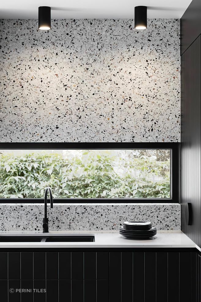 Tiles that feature a bold range of colours or patterns can sometimes feel like a challenge to pair with other materials! A great way to create a sense of cohesion and balance in your colour palette while incorporating pattern tiles is to pick out a single colour from your chosen tile and match this in other areas of your design scheme. This luxurious kitchen for example pairs terrazzo tiles with a black speckled pattern with black kitchen cabinets to create a harmonious look.