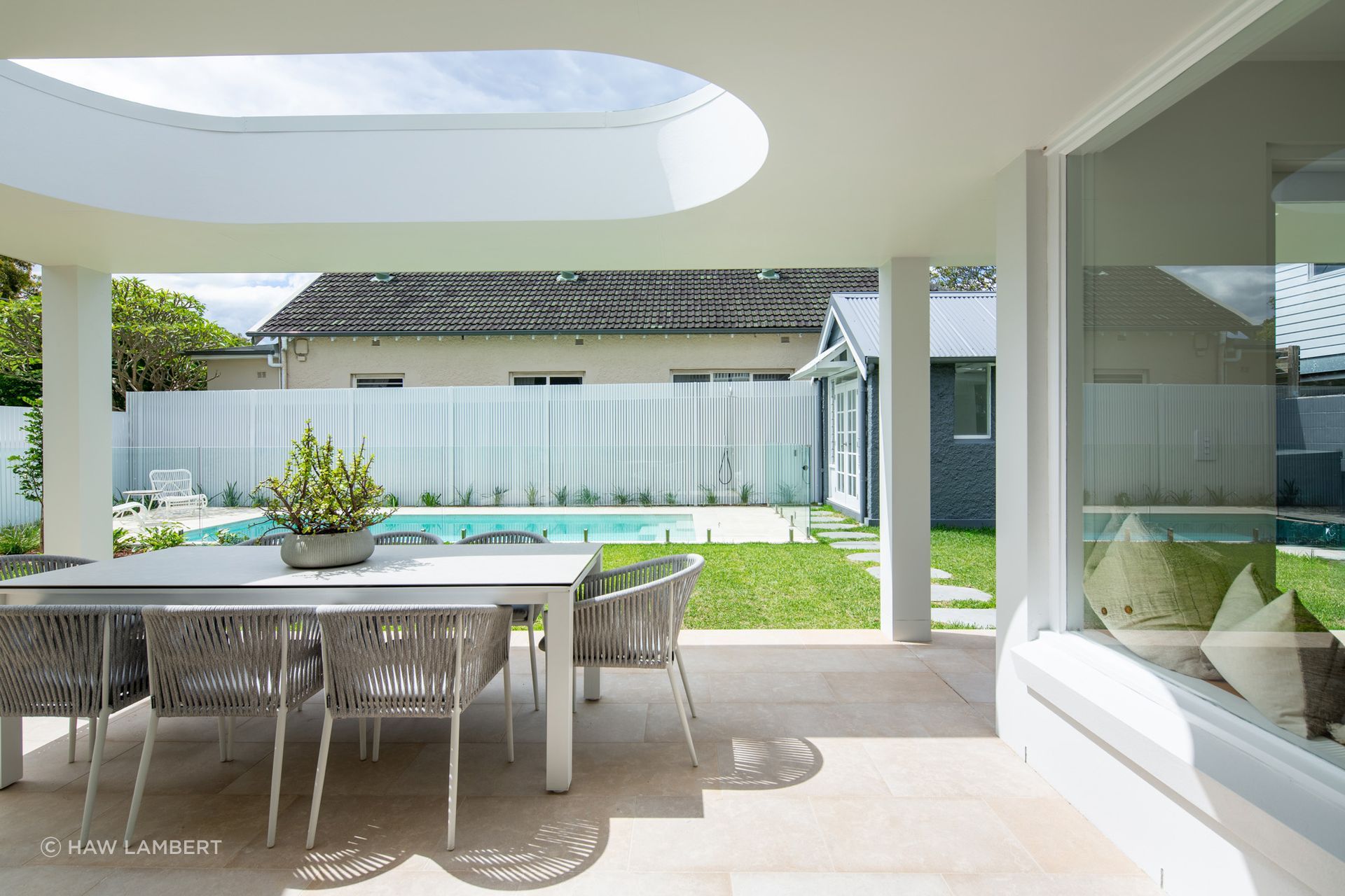Lavarosa Limestone pavers connect the covered alfresco to the pool and garden beyond at Barn House Randwick, a natural foundation for outdoor living.