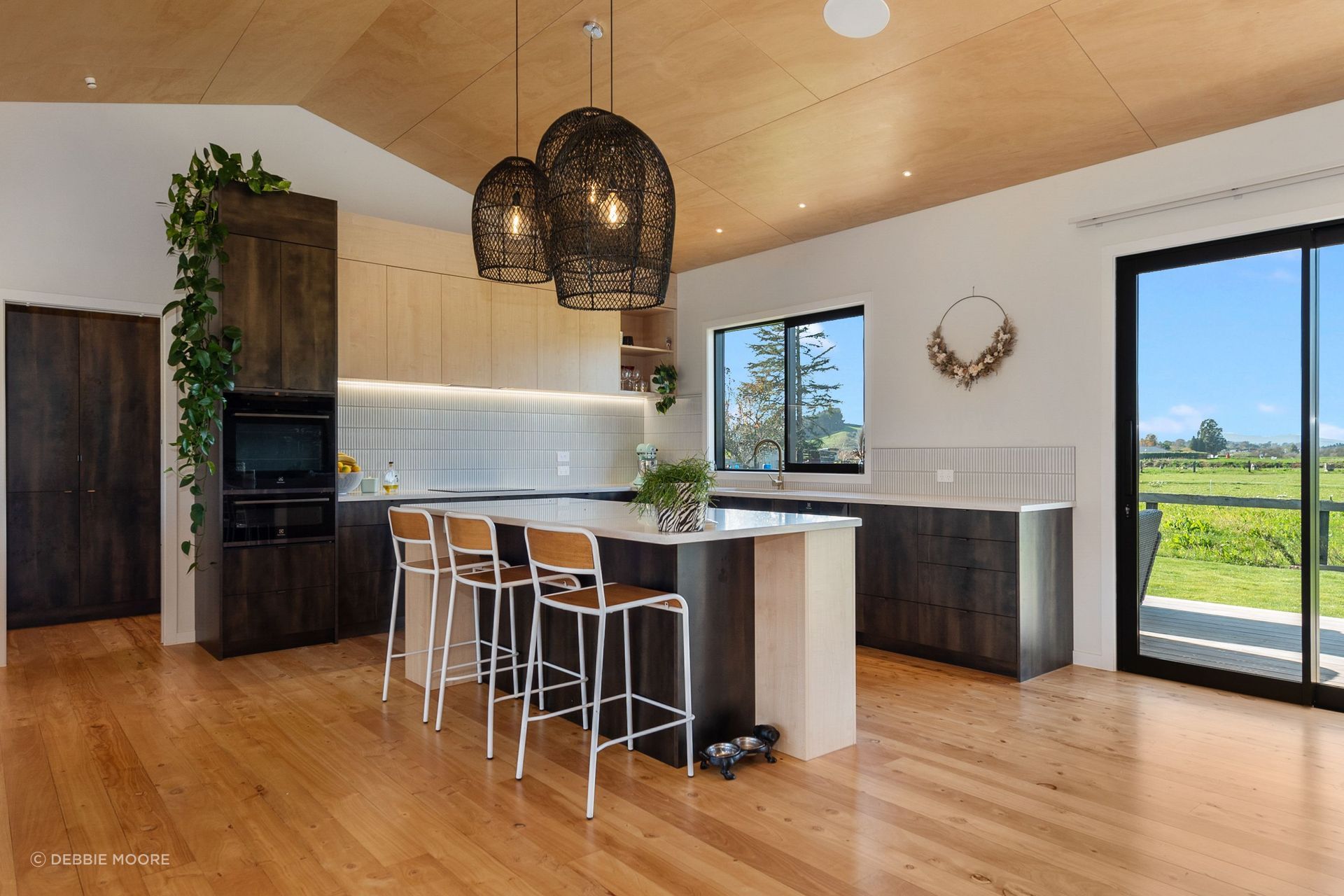 The raked ceiling in the kitchen and living area is finished with ply with negative detailing.