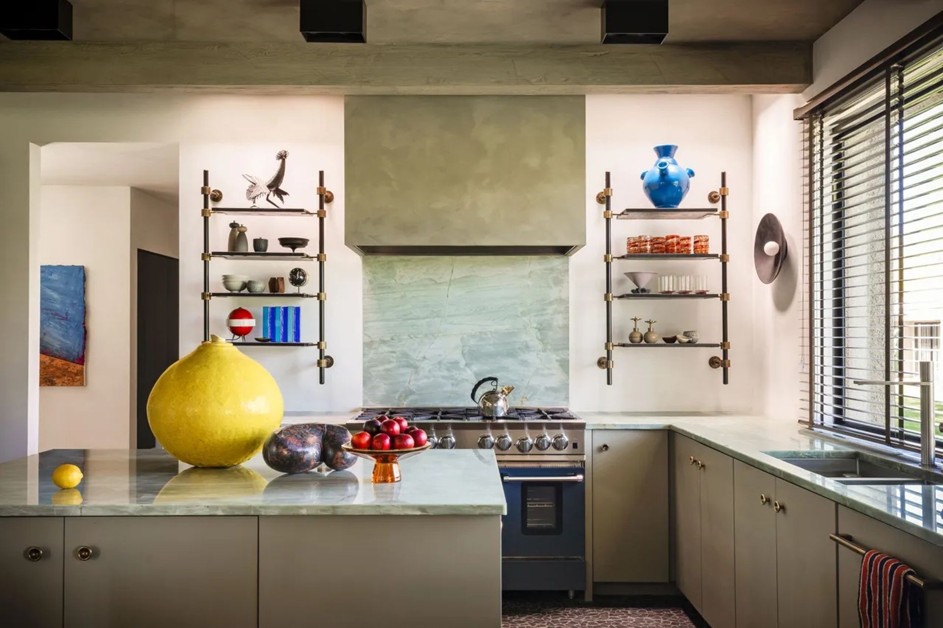 Studio Van Den Akker shelving flanks the kitchen’s stone hood; range by Bluestar. Art: Michel Anasse. Annabel Auger. Studio Van den Akker.