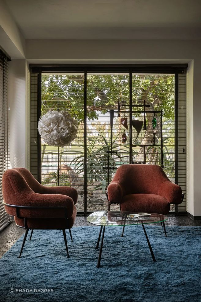Studio Van Den Akker chairs in a fabric by Glant Textiles pull up to a 1950s French table in the primary bedroom; floor lamp by Ingo Maurer and custom carpet by Beni Rugs. Art: Ingo Maurer