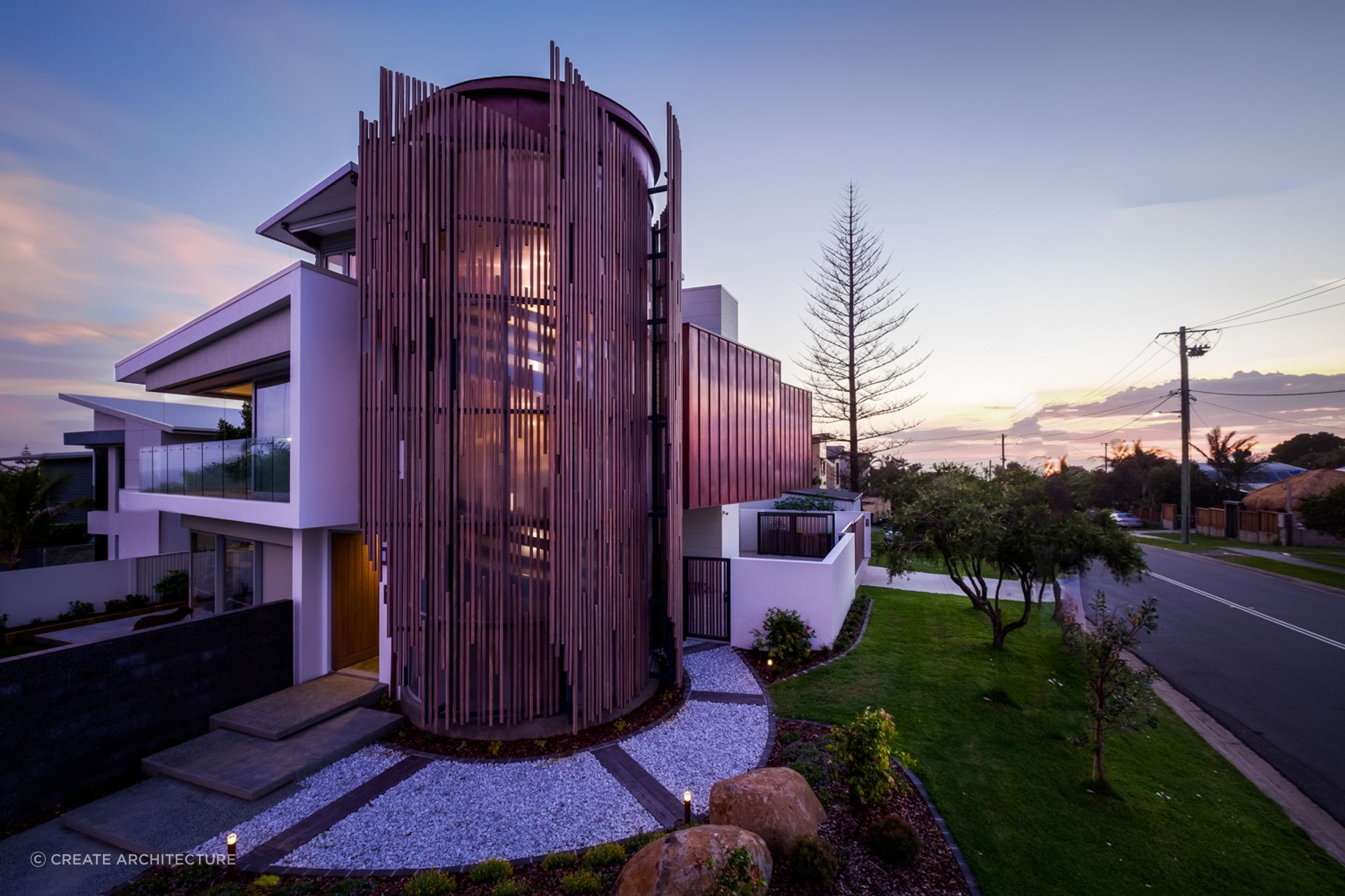 The wooden slats encasing the staircase act as a dramatic light filter.