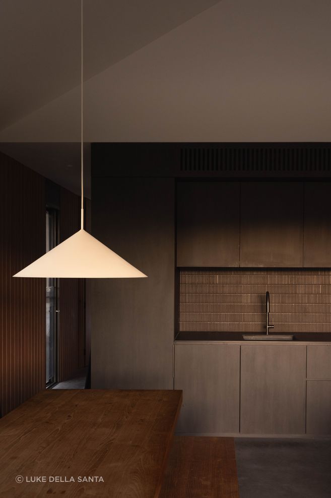 Concrete floors, Blackbutt, grooved wall linings and dark insertions create a warm, restrained palette.