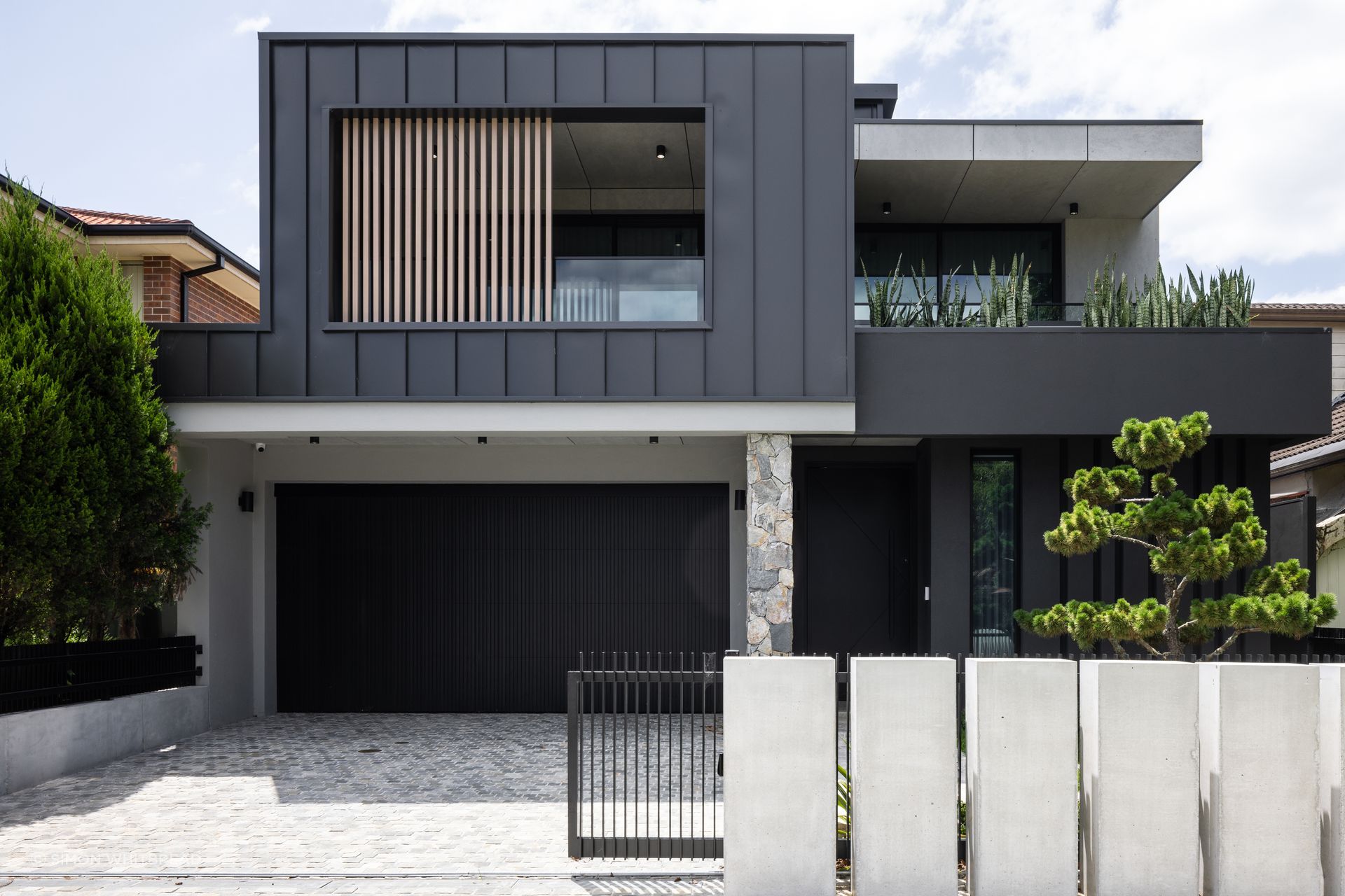 The exterior is a prelude to the interior: concrete, natural stones and dark surfaces.