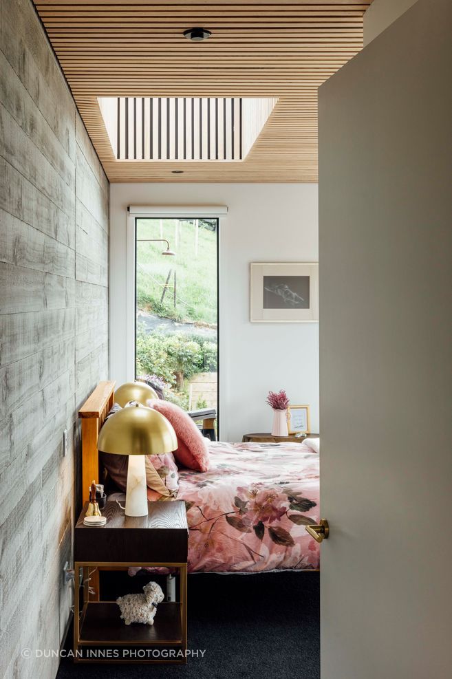 In the main bedroom, the ceilings are clad in American ash battens. “It really gives a warm feel to it,” says Brendon.