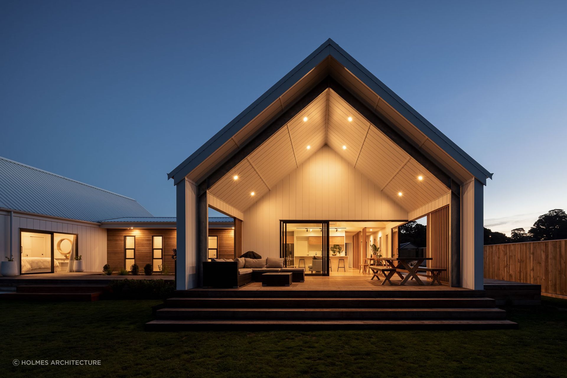 The magnificence of the gabled pavilions and contrasting use of weatherboards can still be appreciated at dusk with its excellent outdoor lighting design. | Photography: André Vroon Photographer