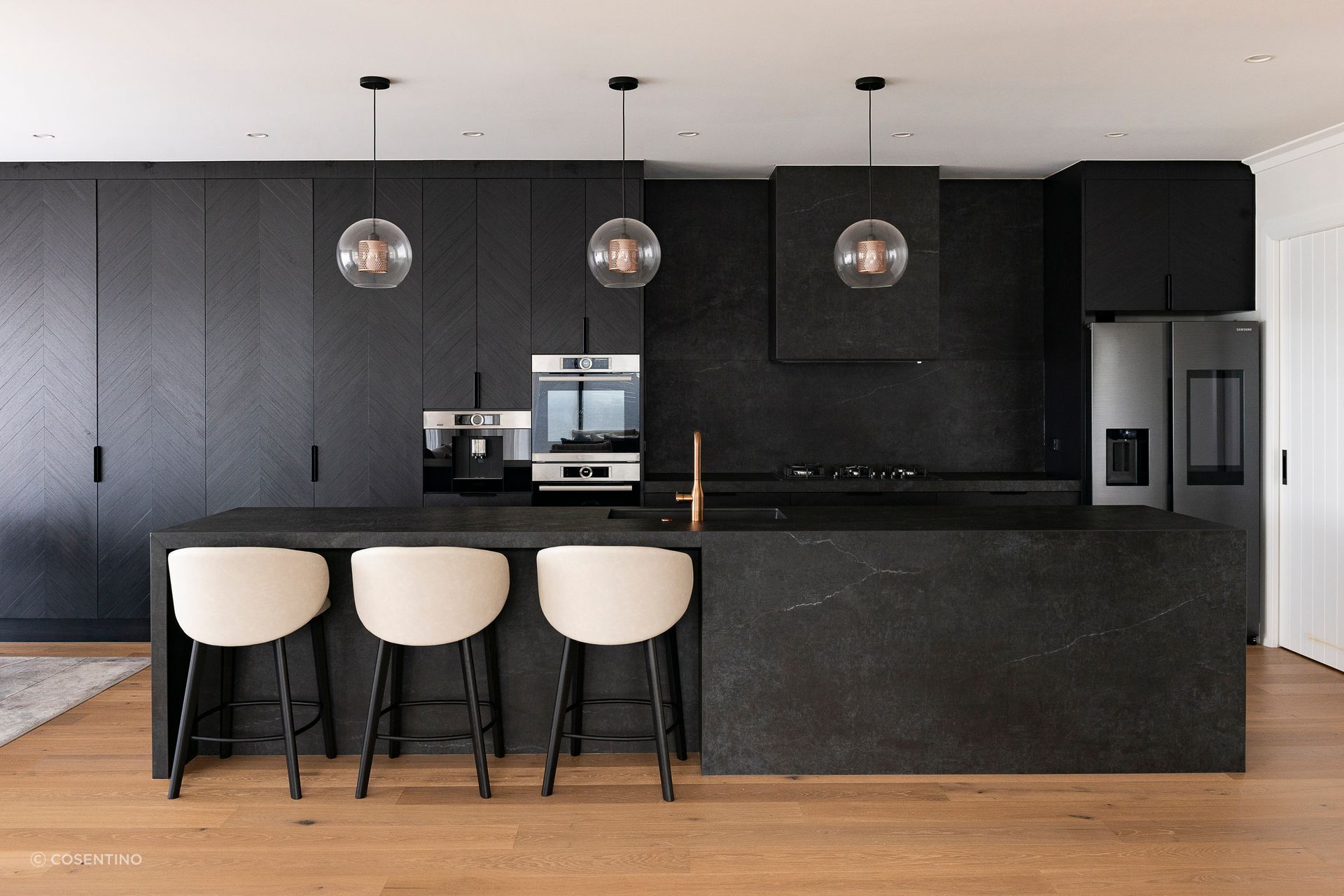 The open-plan kitchen features Dekton Laos on the worktop, splashback, and island.