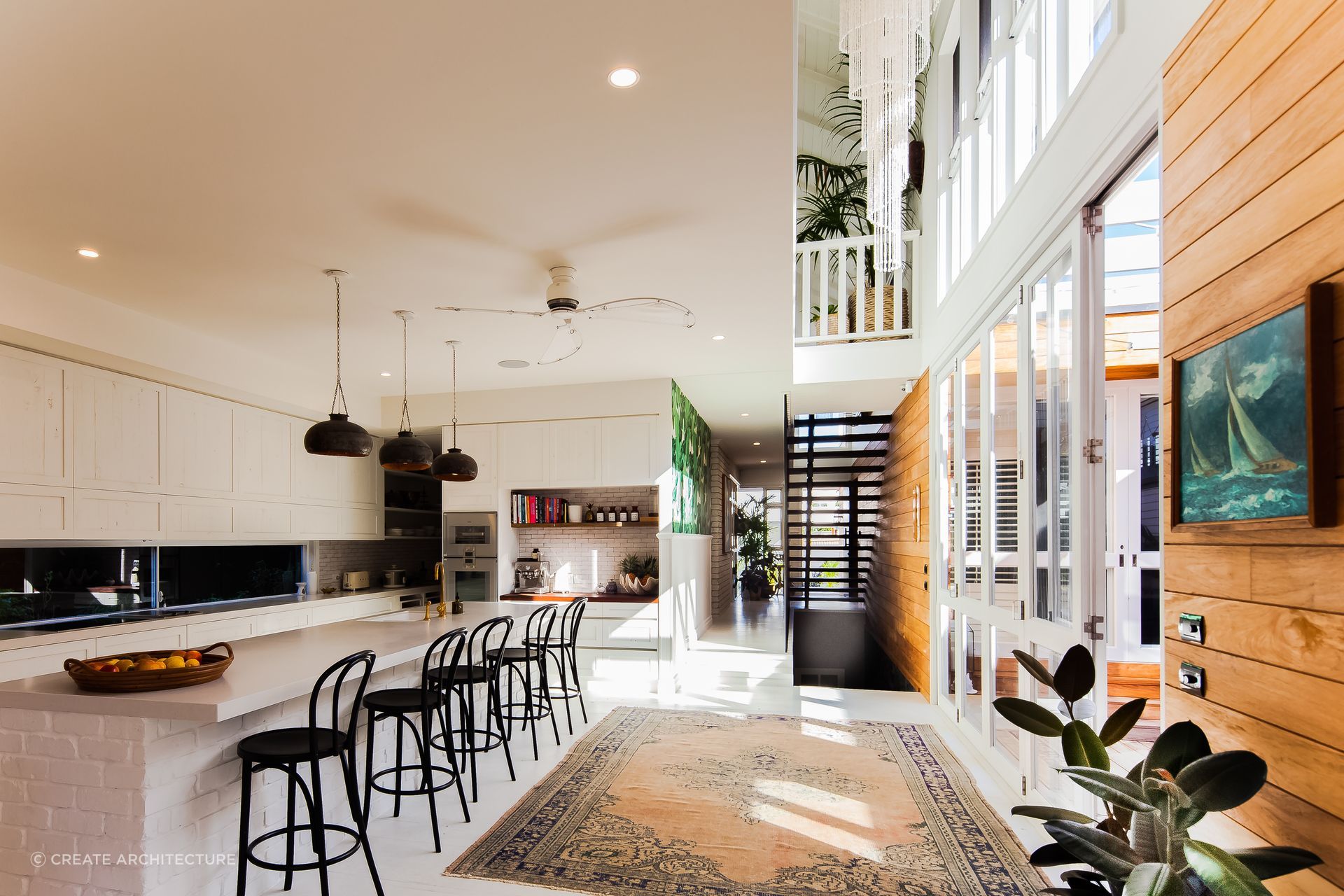 The kitchen island serves as a sturdy centrepiece, beautifully complemented by the regal allure of the kitchen rug. Photography: Andy Macpherson Studio.