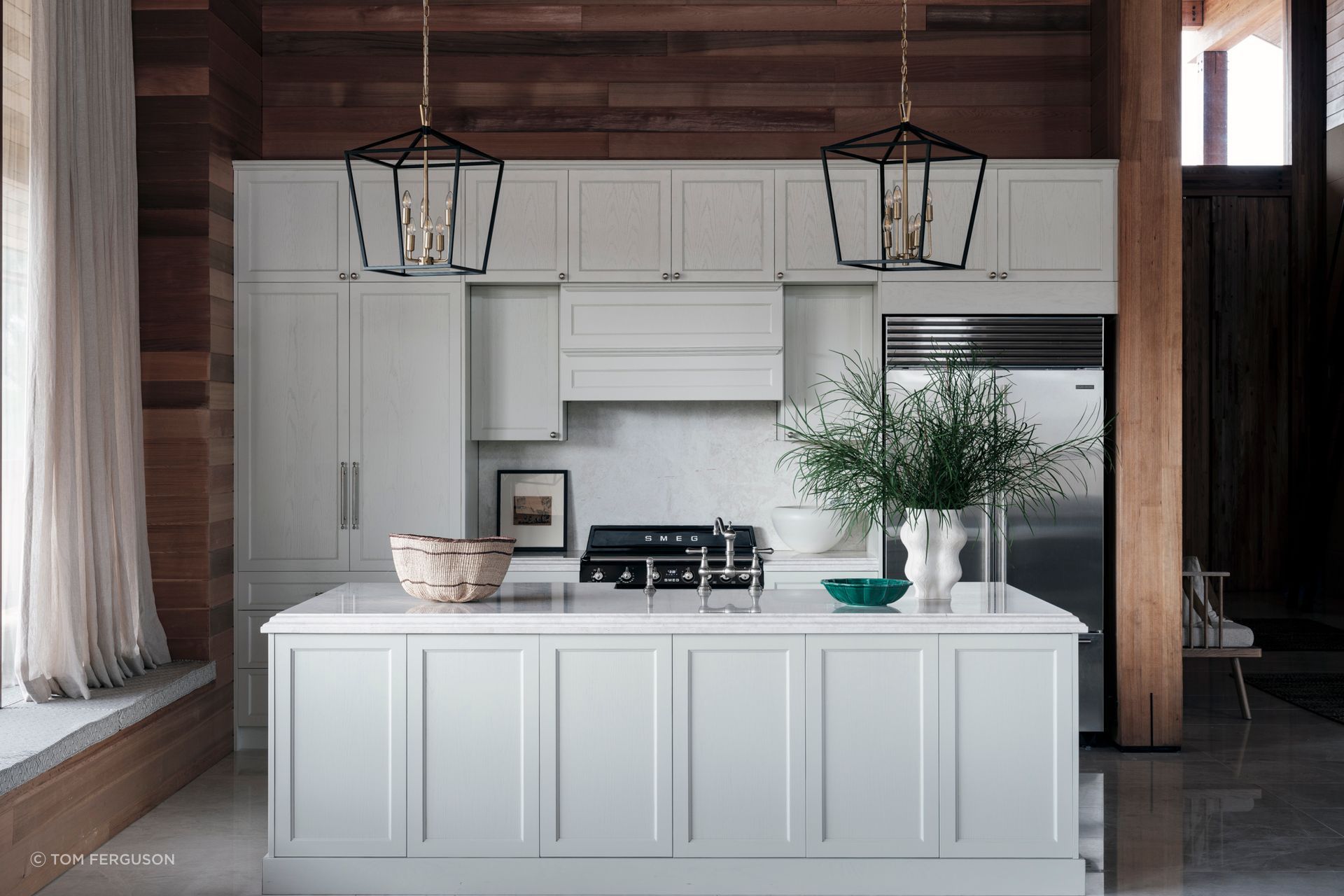 A contrast to the cedar, the kitchen cabinetry is solid oak, hand-painted in white. The orientation of the island bench allows those preparing dinner to look out over the space and still be involved in conversation.